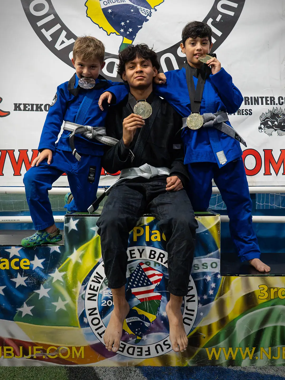 Young Chokelab Academy martial arts students holding their medals after a tournament win in Harrison NJ